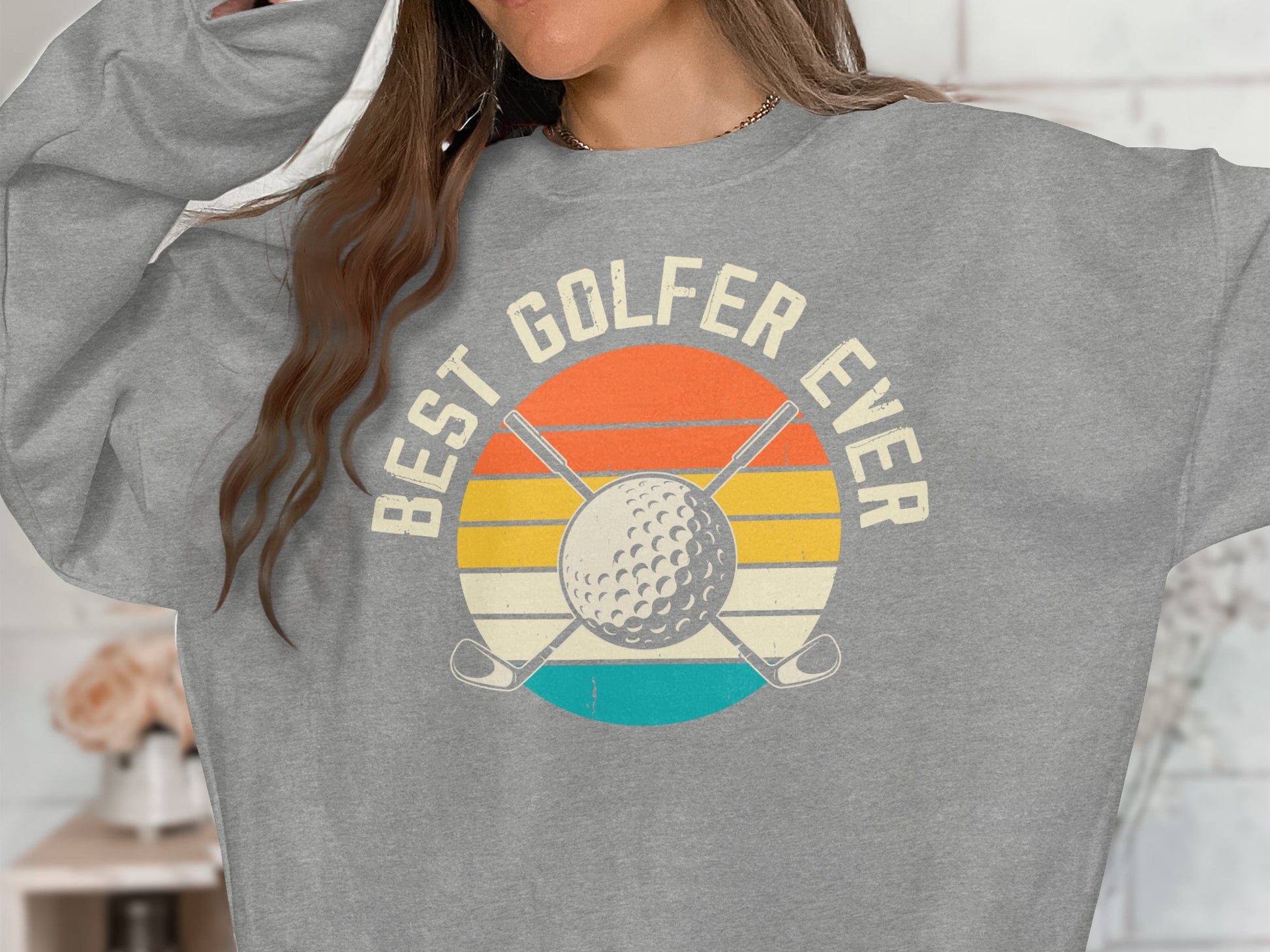 Gray sweatshirt with "BEST GOLFER EVER" text and a golf ball graphic.