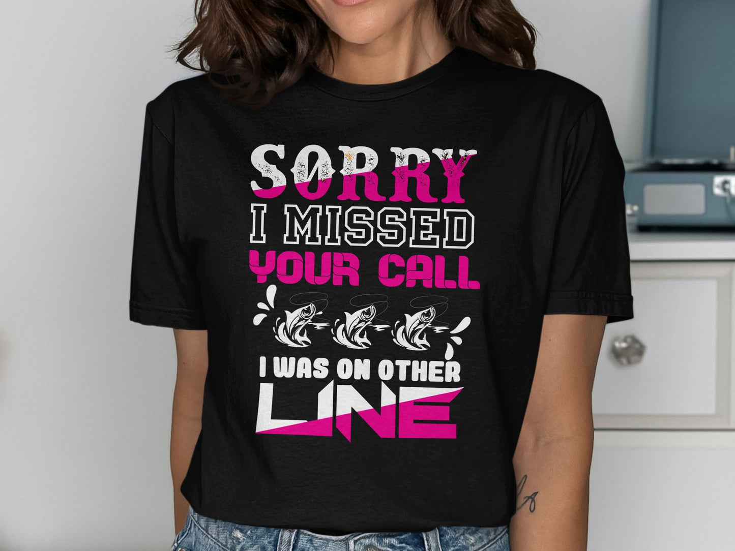 Black t-shirt with pink and white text: "SORRY I MISSED YOUR CALL I WAS ON OTHER LINE" and three fish.