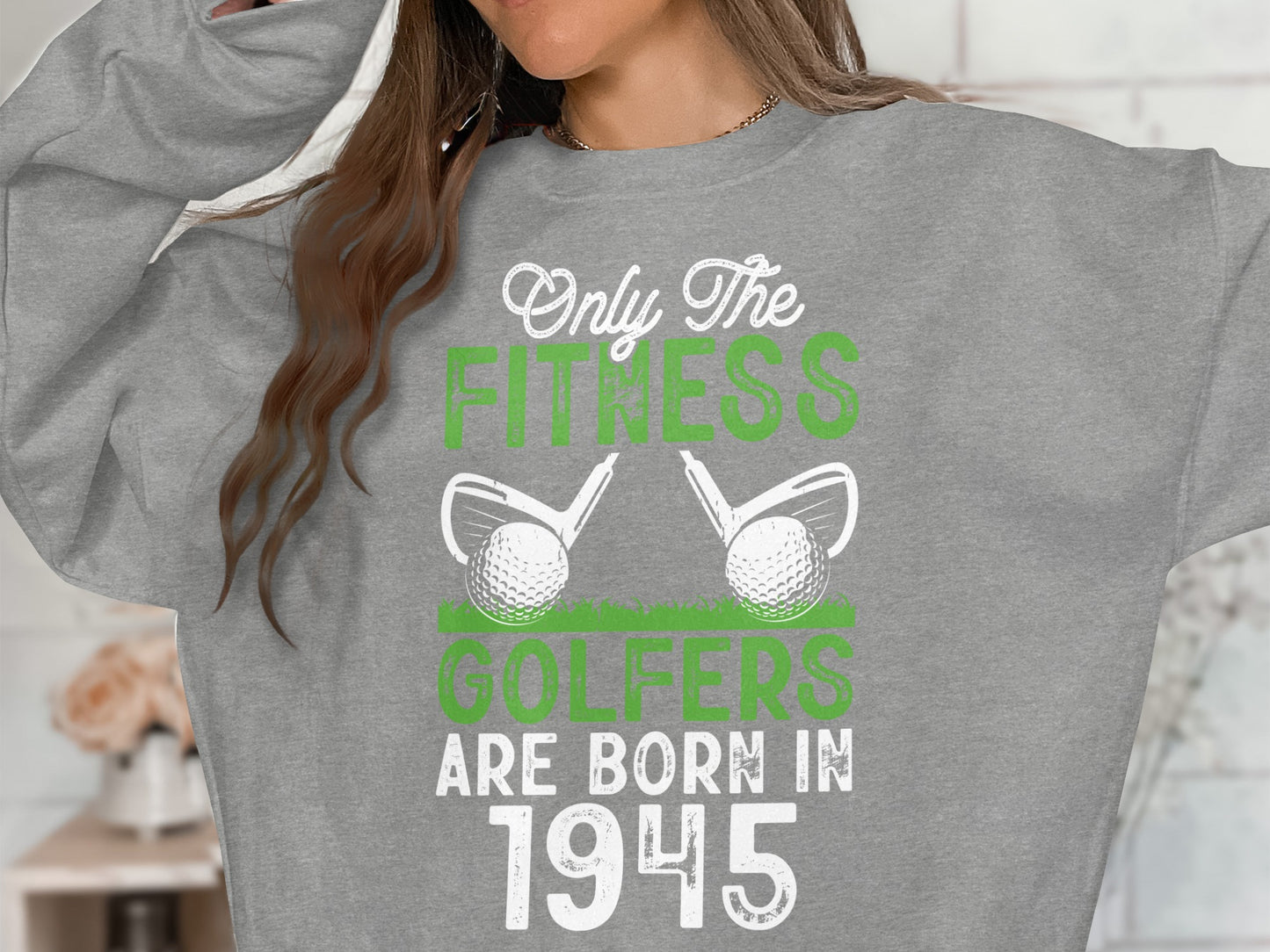 Gray sweatshirt with "Only The Fitness Golfers Are Born In 1945" and golf clubs.