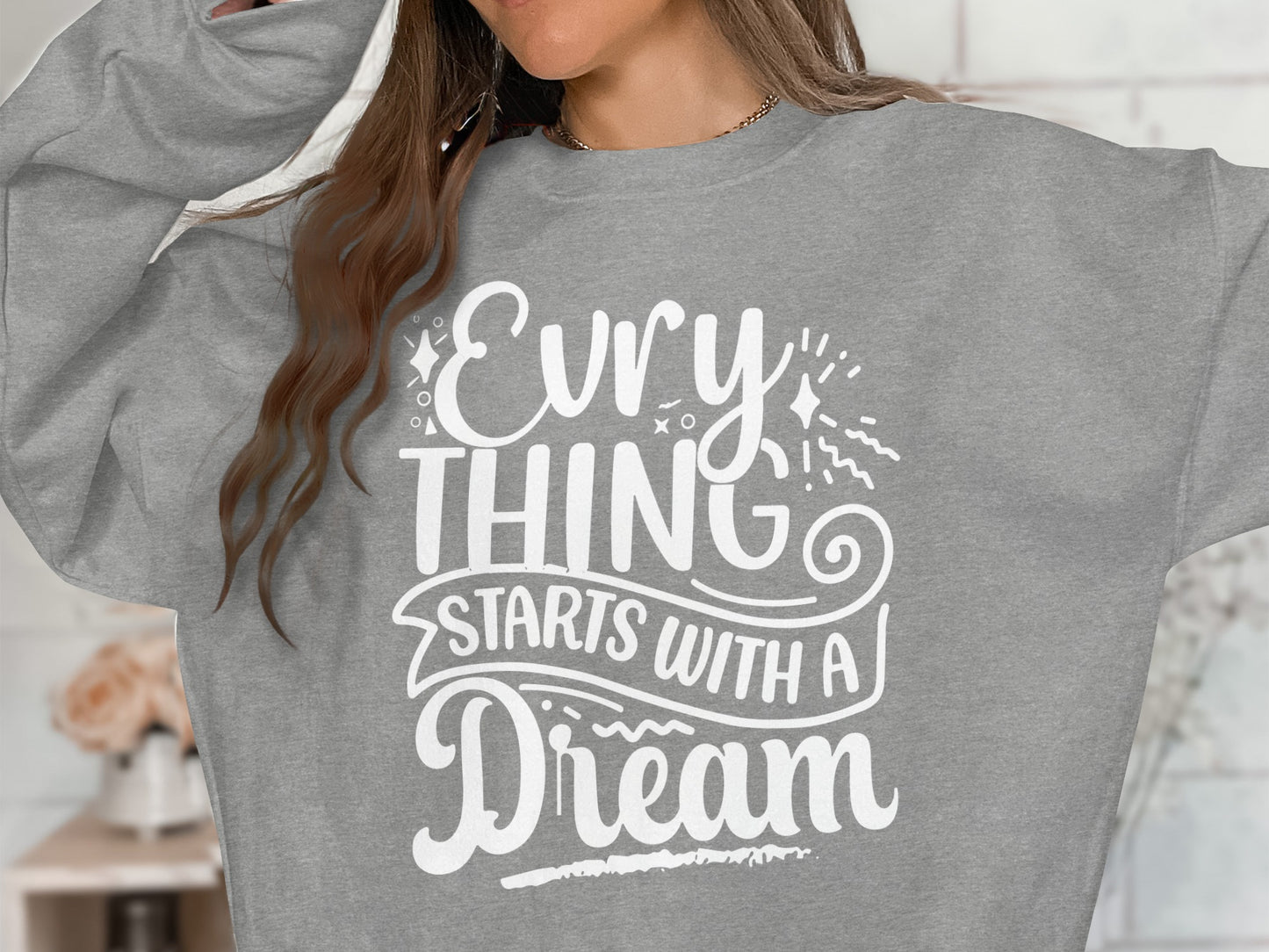 Gray sweatshirt with "EVERYTHING STARTS WITH A DREAM" in white text.