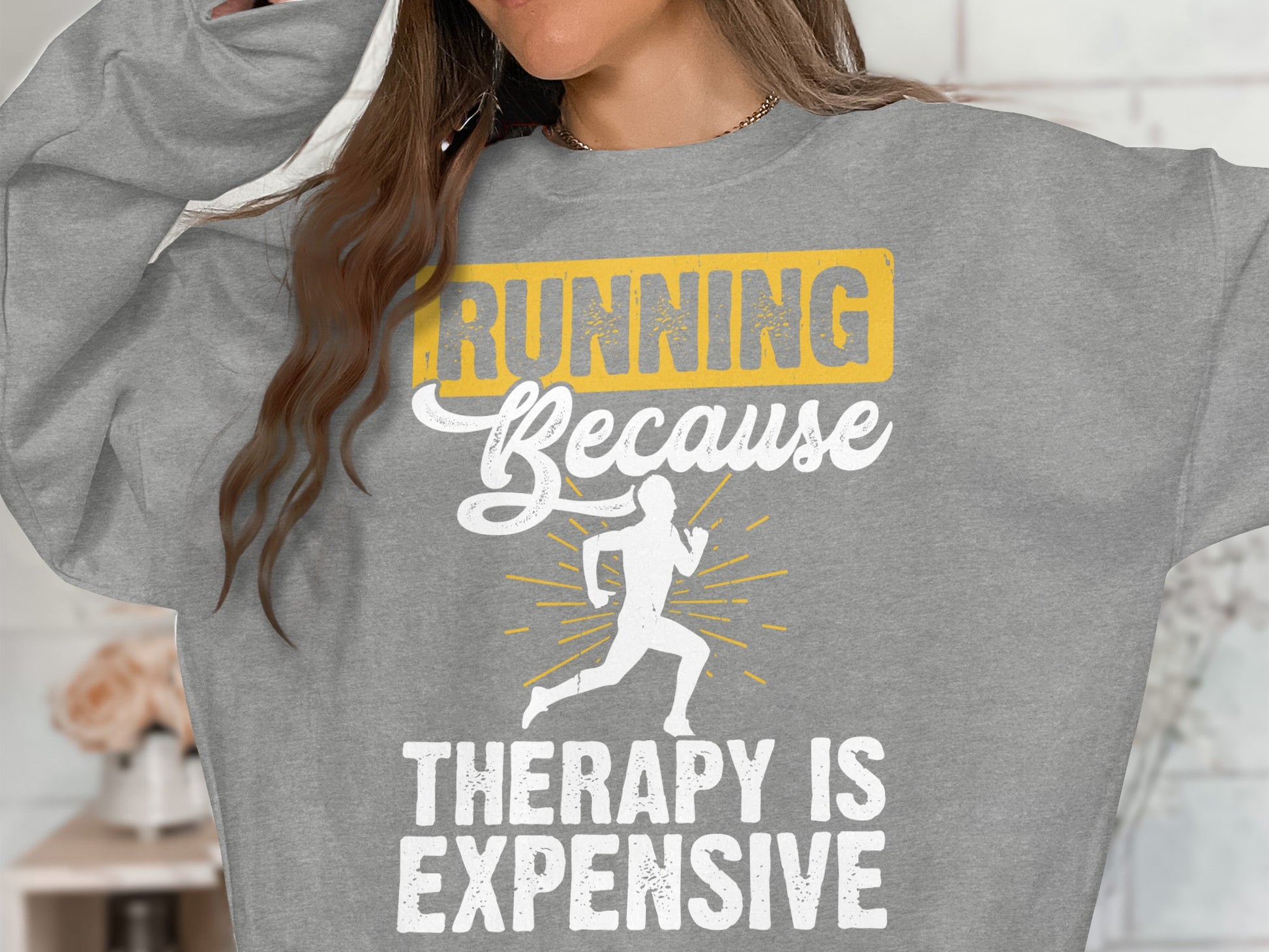 Grey sweatshirt with "Running Because Therapy Is Expensive" and running silhouette.