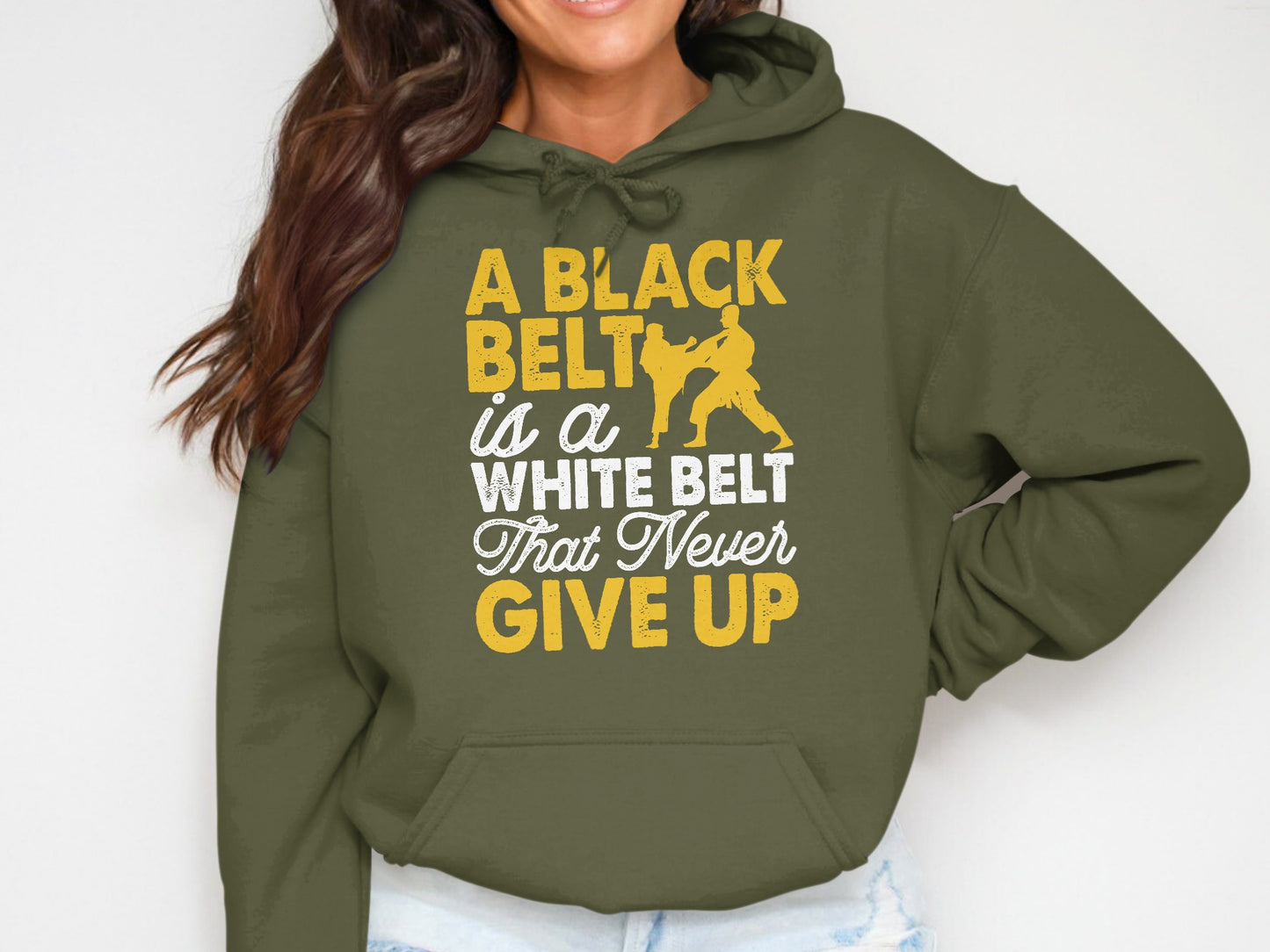 Olive green hoodie with "A black belt is a white belt that never give up" text and karate graphic.