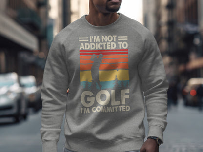 Gray sweatshirt with "I'm Not Addicted To Golf I'm Committed" and a sunset golf scene.