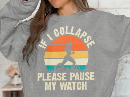 Grey sweatshirt with "IF I COLLAPSE PLEASE PAUSE MY WATCH" text and runner graphic.