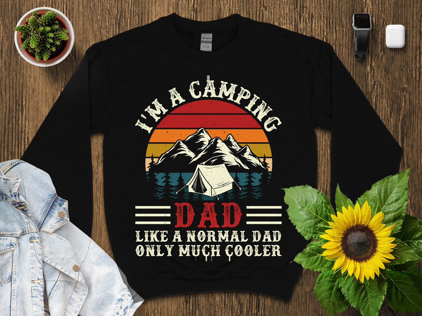 Black sweatshirt with "I'm a camping dad, like a normal dad, only much cooler" text and camping graphic.