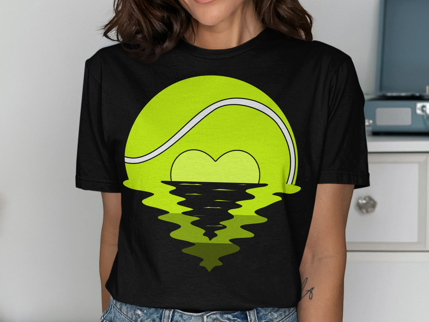 Tennis ball with heart reflection over water.