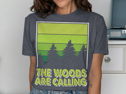 Dark grey t-shirt with green striped forest scene and text "The Woods Are Calling".