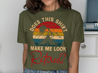 Olive green t-shirt with a sunset, tent, and mountains design and "DOES THIS SHIRT MAKE ME LOOK RETIRED?" text.