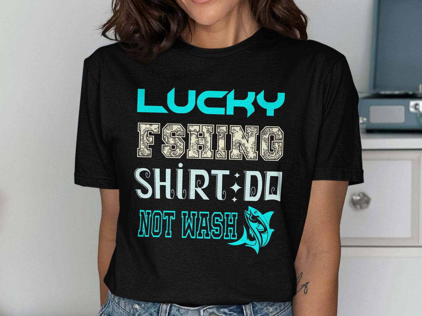 Black t-shirt with "Lucky Fishing Shirt Do Not Wash" text and fish graphic.