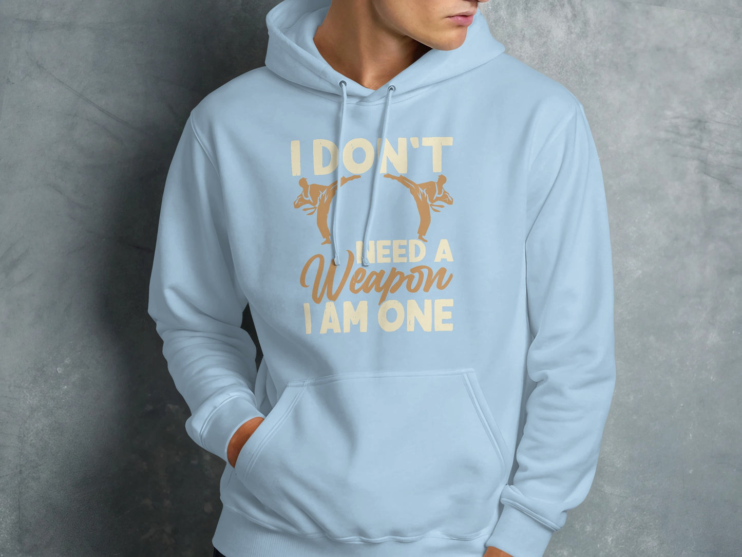 Light blue hoodie with "I DON'T NEED A WEAPON I AM ONE" text and martial arts graphics.