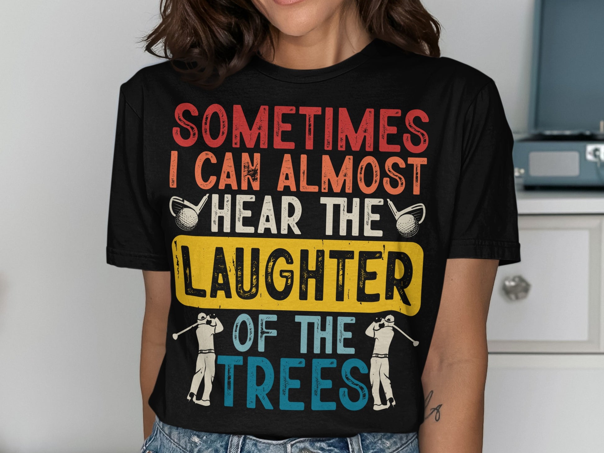 T-shirt with "Sometimes I can almost hear the laughter of the trees" text and golf imagery.