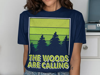 Dark blue t-shirt with green striped forest graphic and text "THE WOODS ARE CALLING".