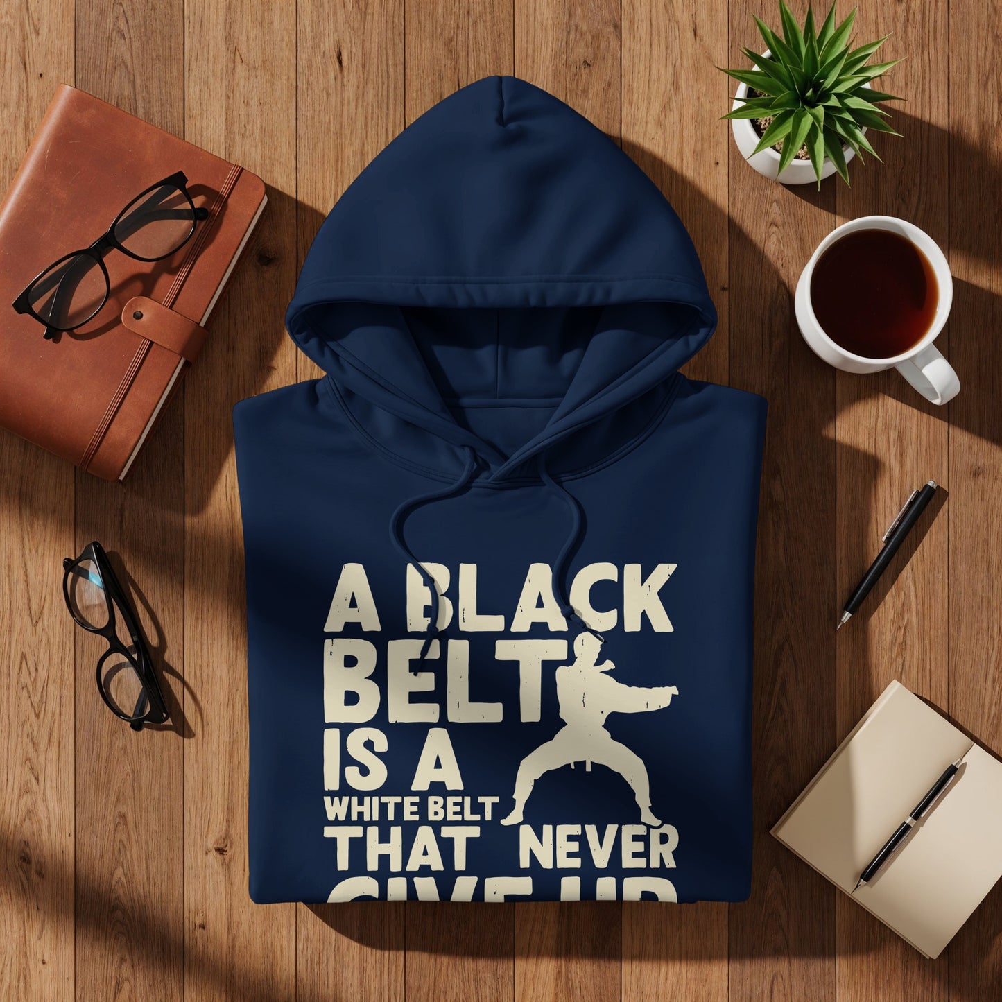 Navy hoodie with "A BLACK BELT IS A WHITE BELT THAT NEVER GIVE UP" graphic.