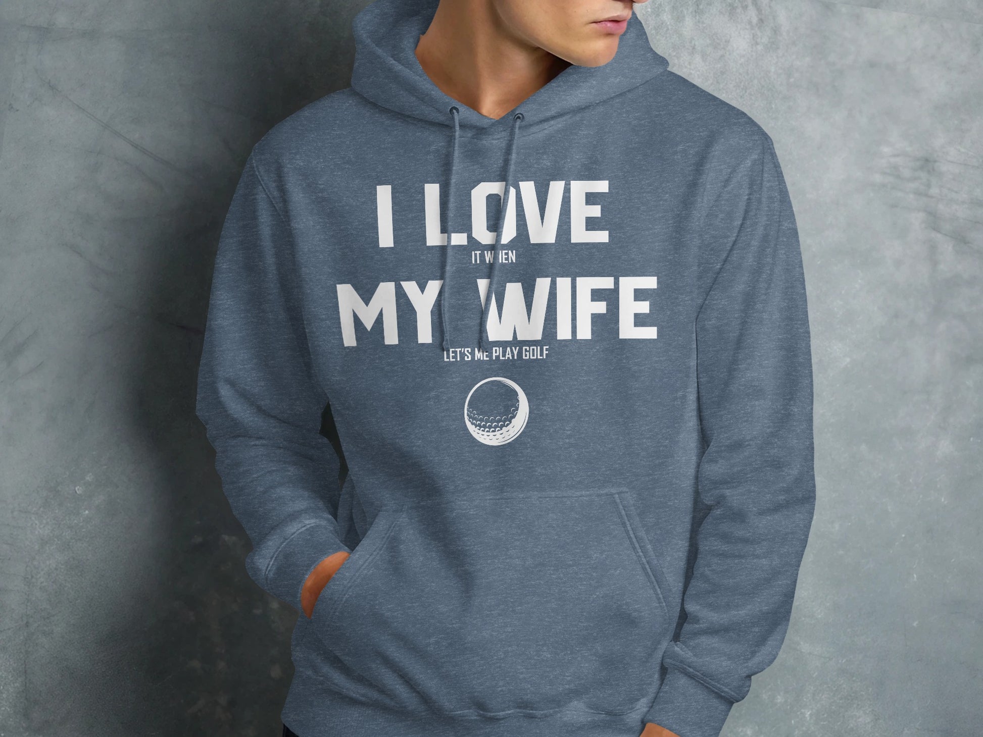 Blue hoodie with white text "I love it when my wife lets me play golf" and a golf ball graphic.