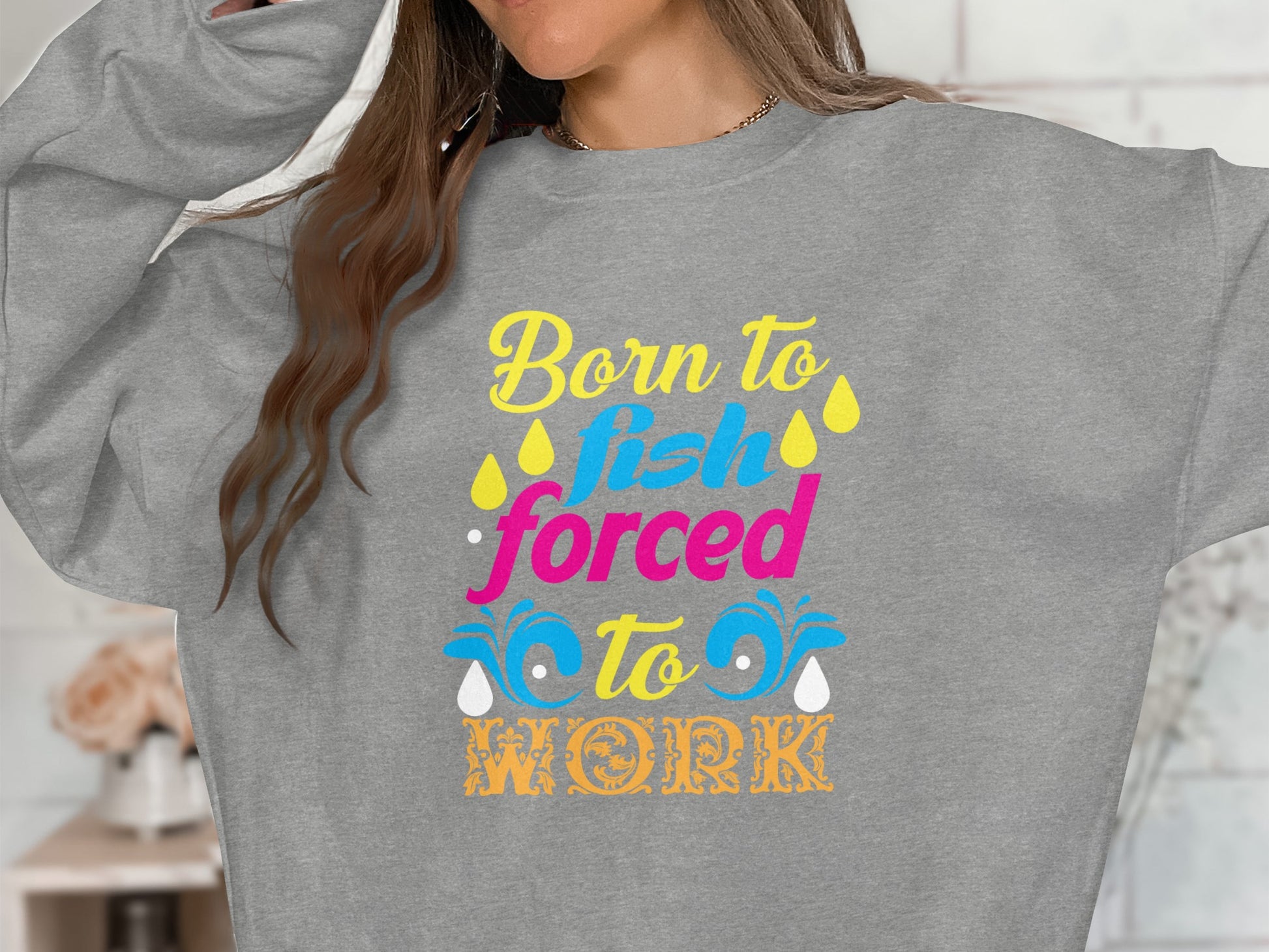 Gray sweatshirt with "Born to Fish, Forced to Work" text and colorful drops.