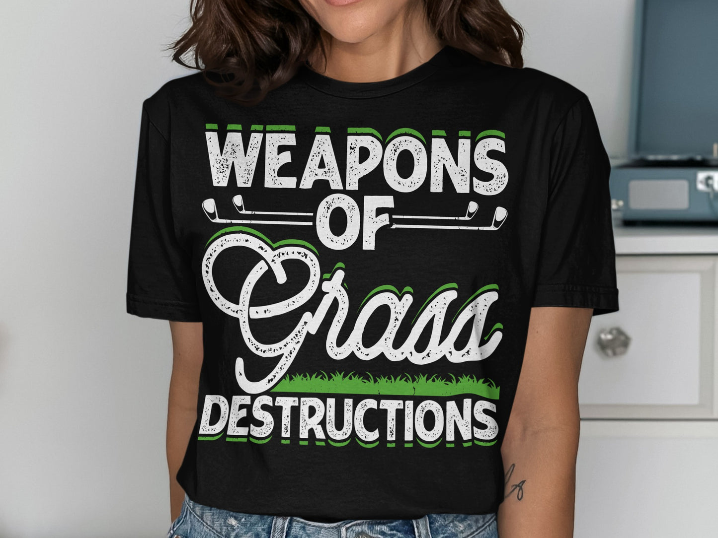 Black t-shirt with "WEAPONS OF GRASS DESTRUCTIONS" text and golf clubs.