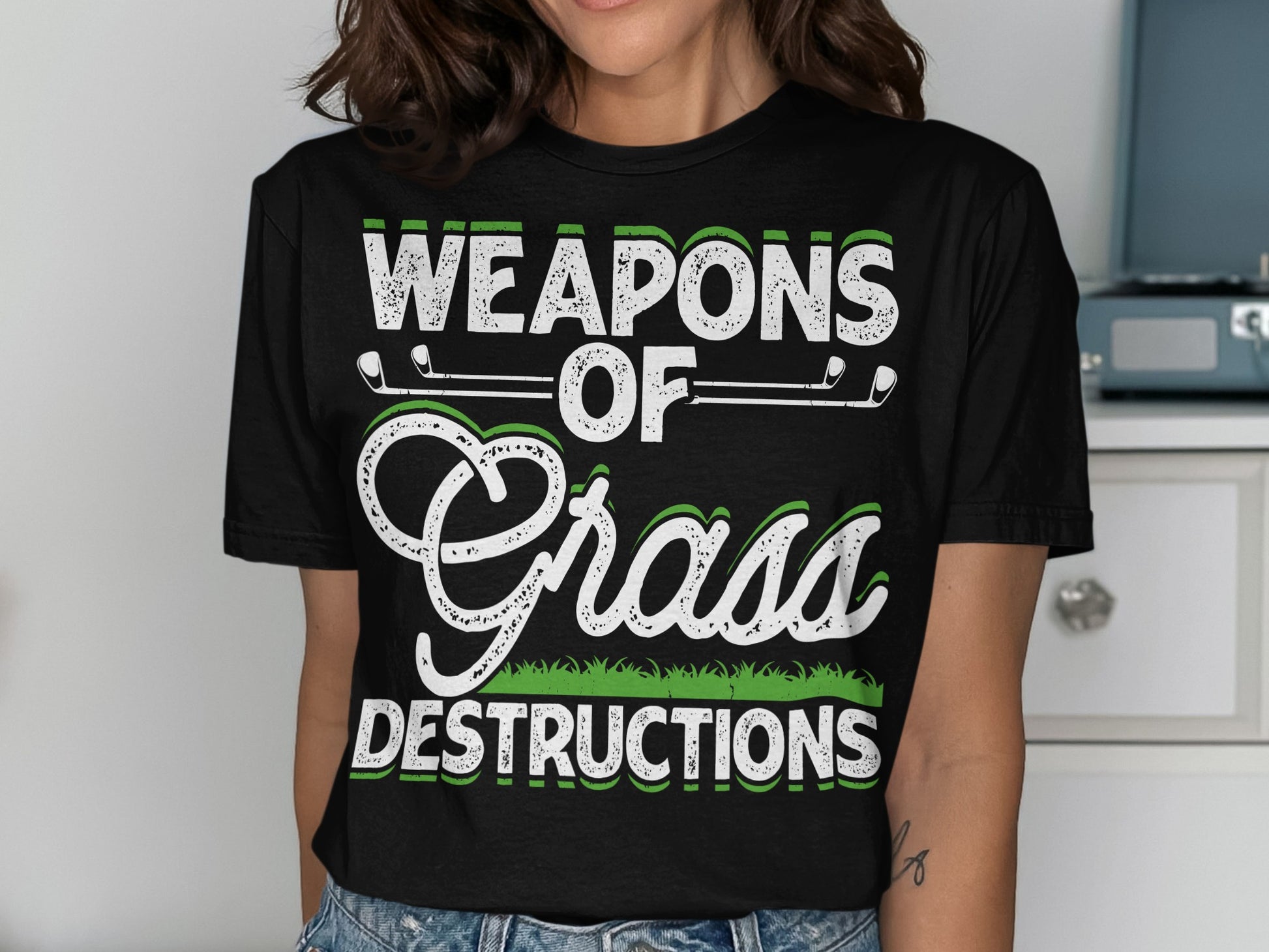 Black t-shirt with "WEAPONS OF GRASS DESTRUCTIONS" text and golf clubs.