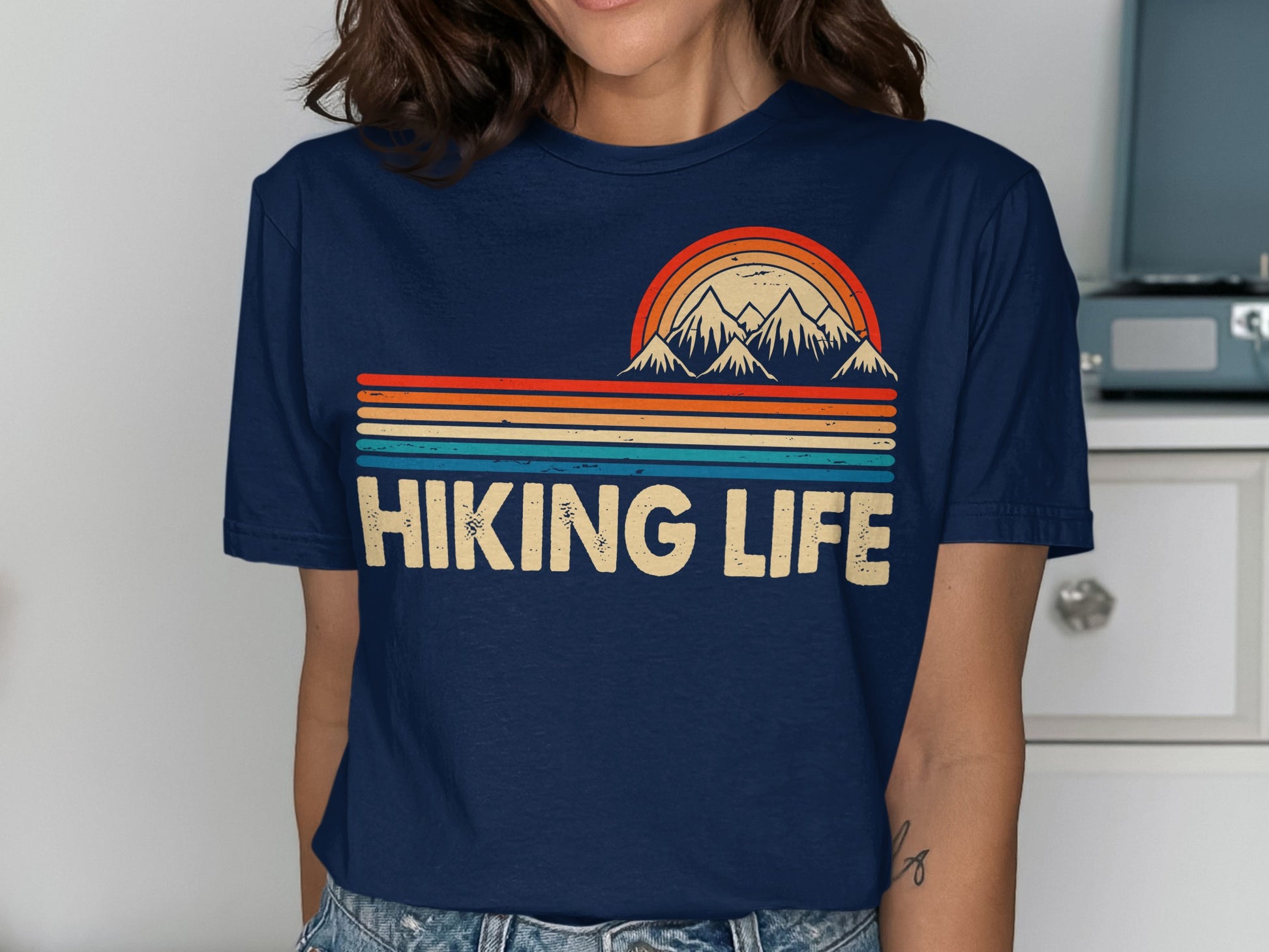 Navy t-shirt with "Hiking Life" text and colorful mountain sunset graphic.