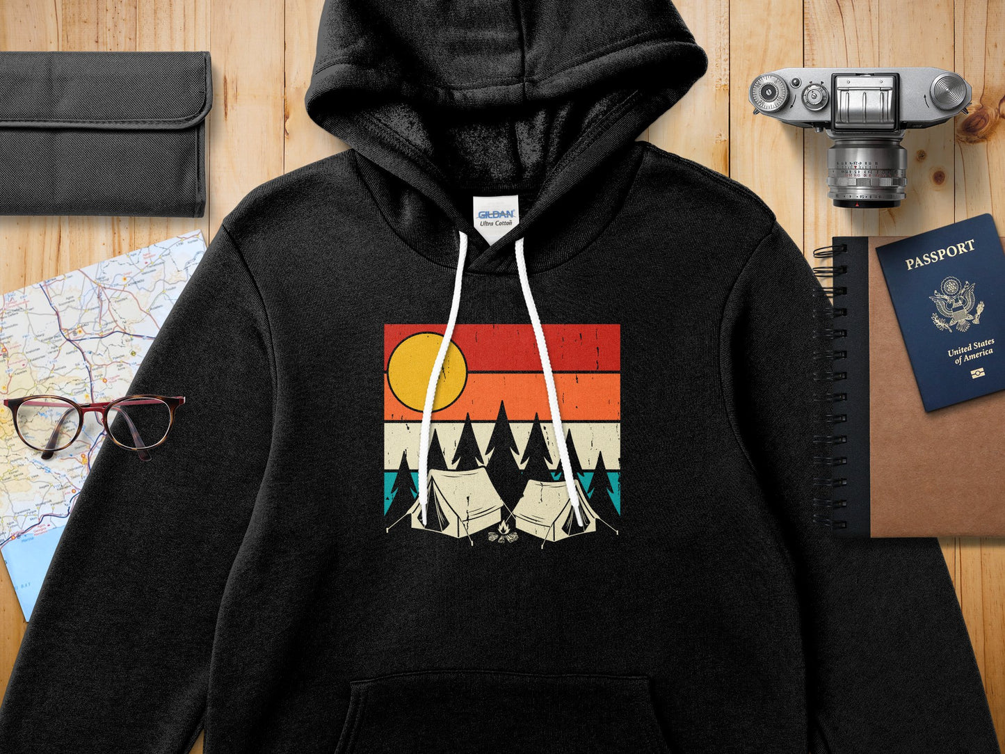 Black hoodie with a graphic of tents and a sunset.