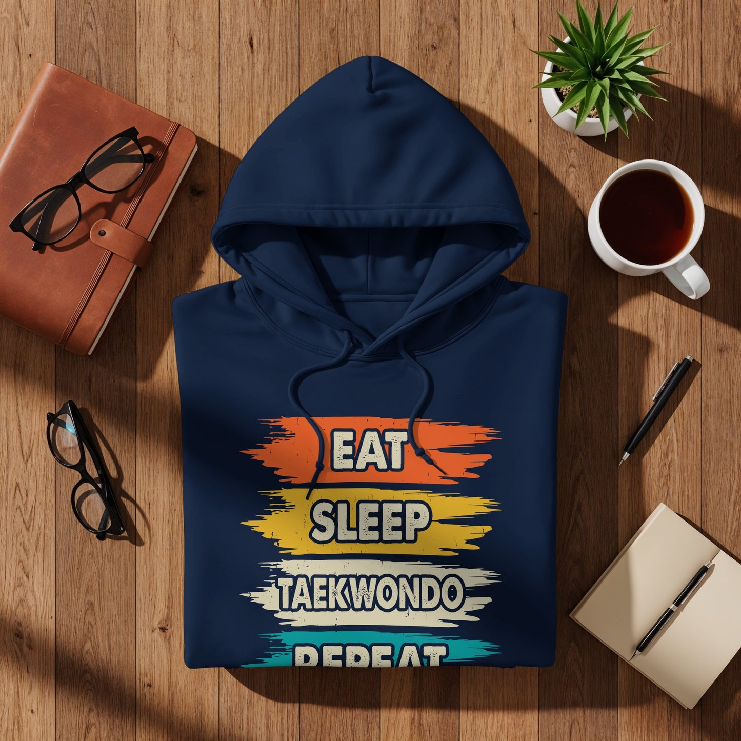 Navy blue hoodie with "Eat Sleep Taekwondo Repeat" text in colorful stripes.