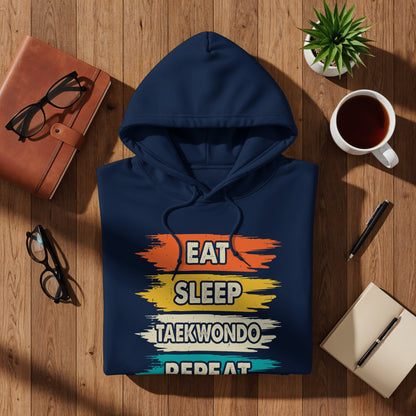 Navy blue hoodie with "Eat Sleep Taekwondo Repeat" text in colorful stripes.