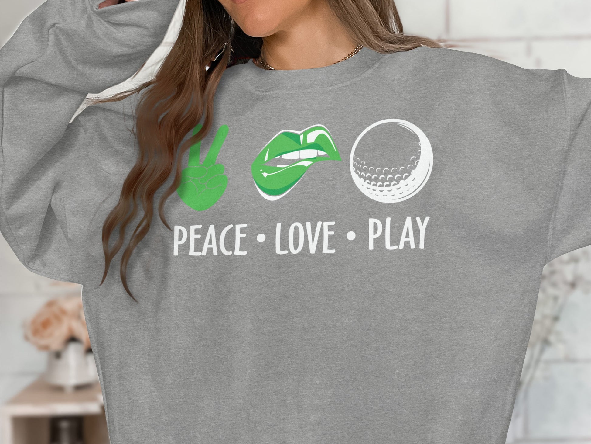 Grey sweatshirt with "Peace Love Play" and symbols: peace sign, lips, golf ball.