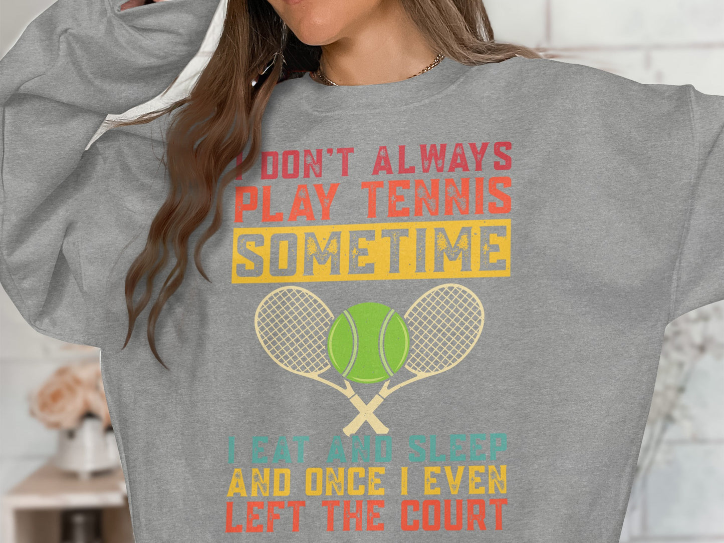 Grey sweatshirt with "I DON'T ALWAYS PLAY TENNIS SOMETIME I EAT AND SLEEP LEFT THE COURT" text.