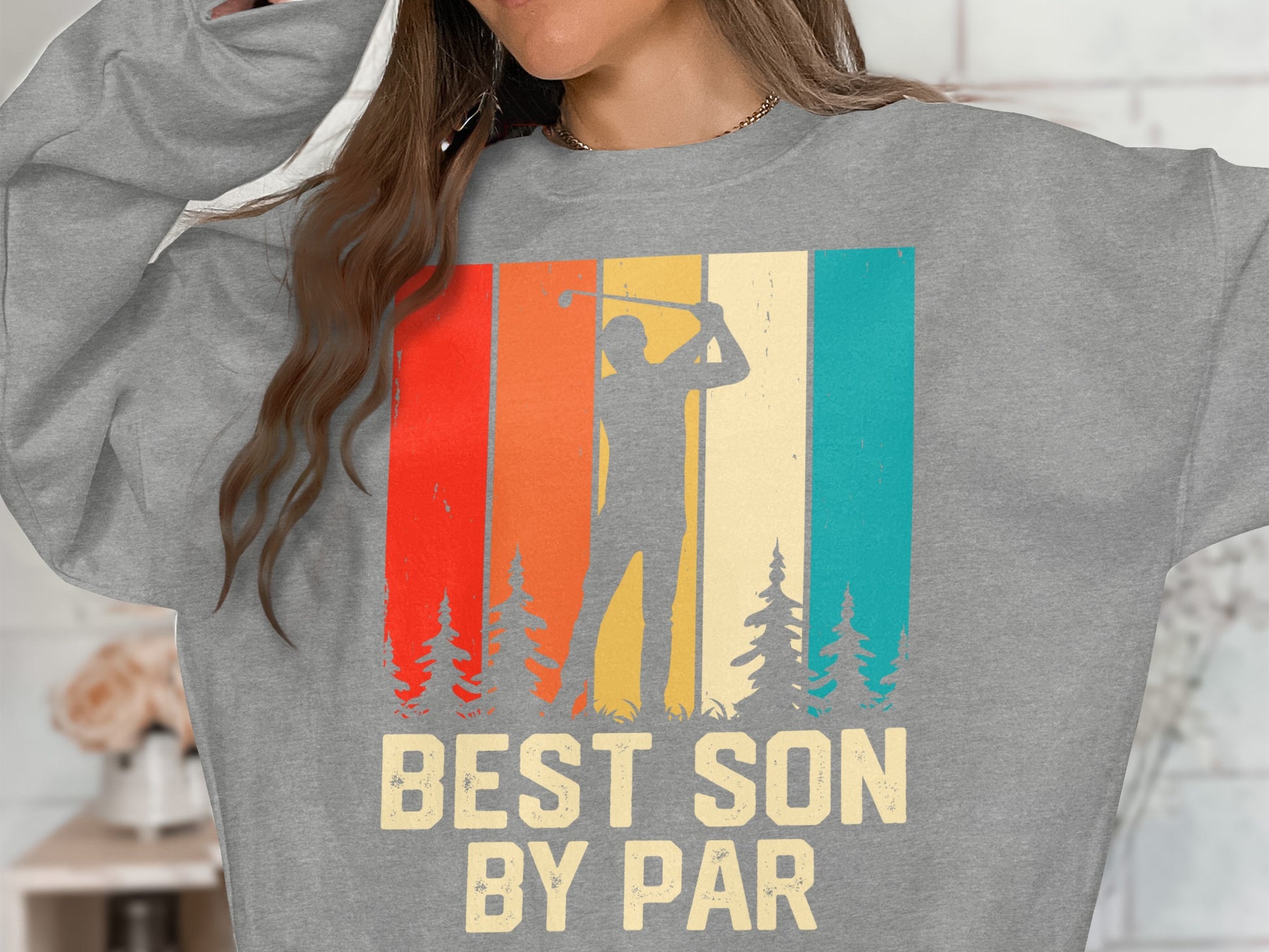 Grey sweatshirt with "BEST SON BY PAR" and a golfer silhouette against striped background.