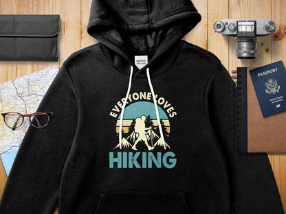 Black hoodie with "Everyone Loves Hiking" text and mountain graphic.
