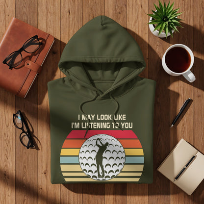 Green hoodie with "I may look like I'm listening 12 you" and golf ball graphic.