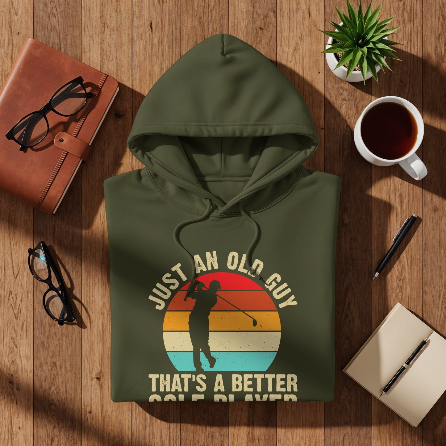 Olive green hoodie with "Just an old guy that's a better golfer" text and golfer graphic.
