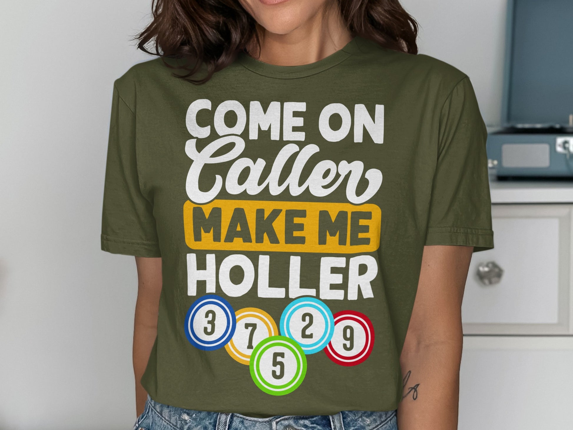 Olive green t-shirt with "Come On Caller Make Me Holler" and bingo balls.