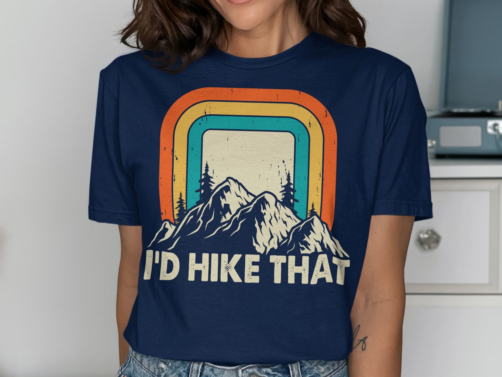 Navy t-shirt with mountains, retro rainbow, and "I'd Hike That" text.