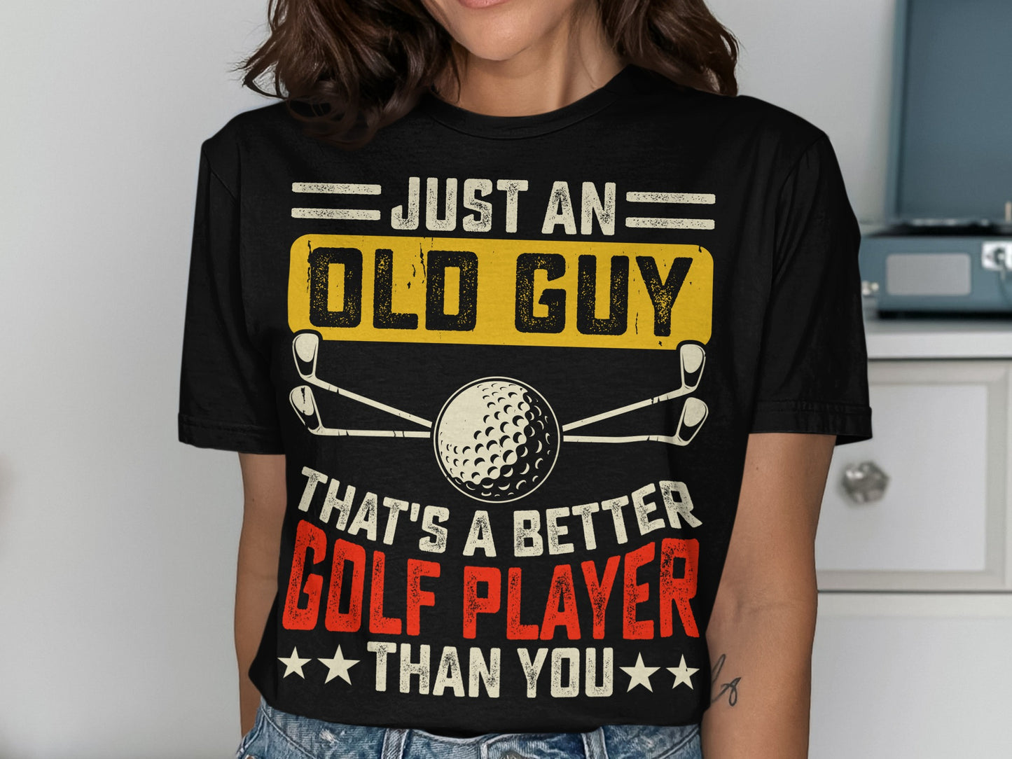 Black t-shirt with "Just an Old Guy That's a Better Golf Player Than You" text and golf graphic.