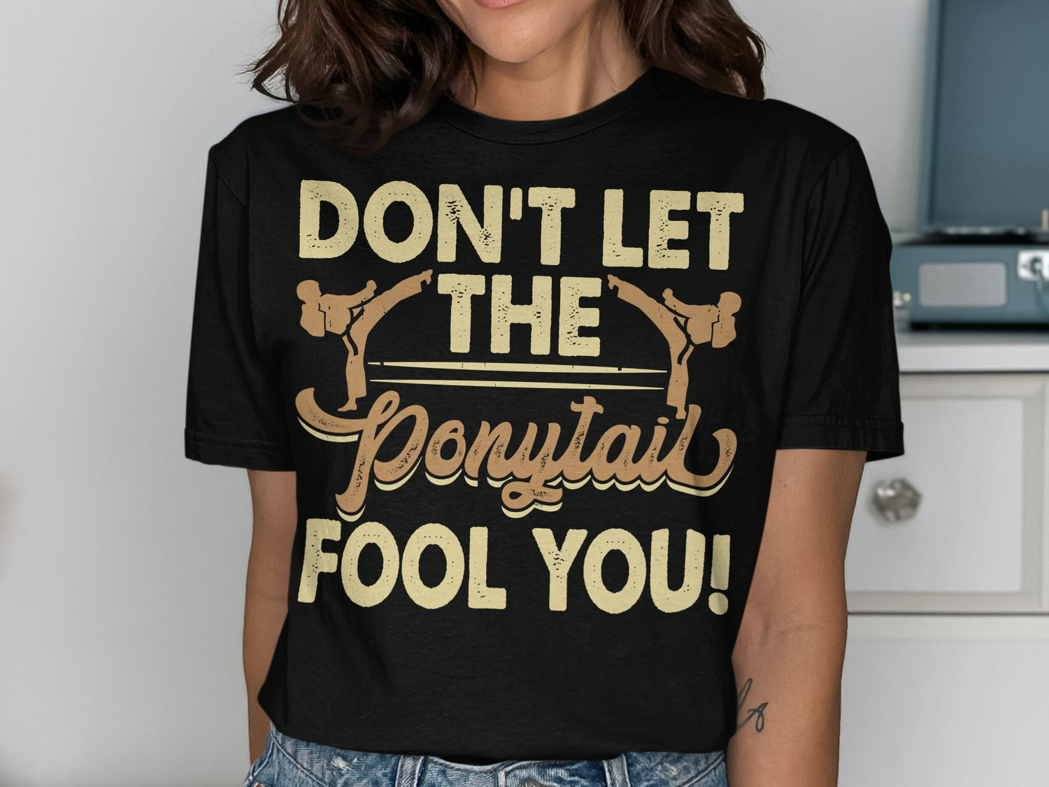 Black t-shirt with "DON'T LET THE PONYTAIL FOOL YOU!" text.