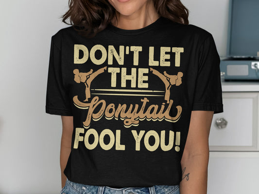 Black t-shirt with "DON'T LET THE PONYTAIL FOOL YOU!" text.