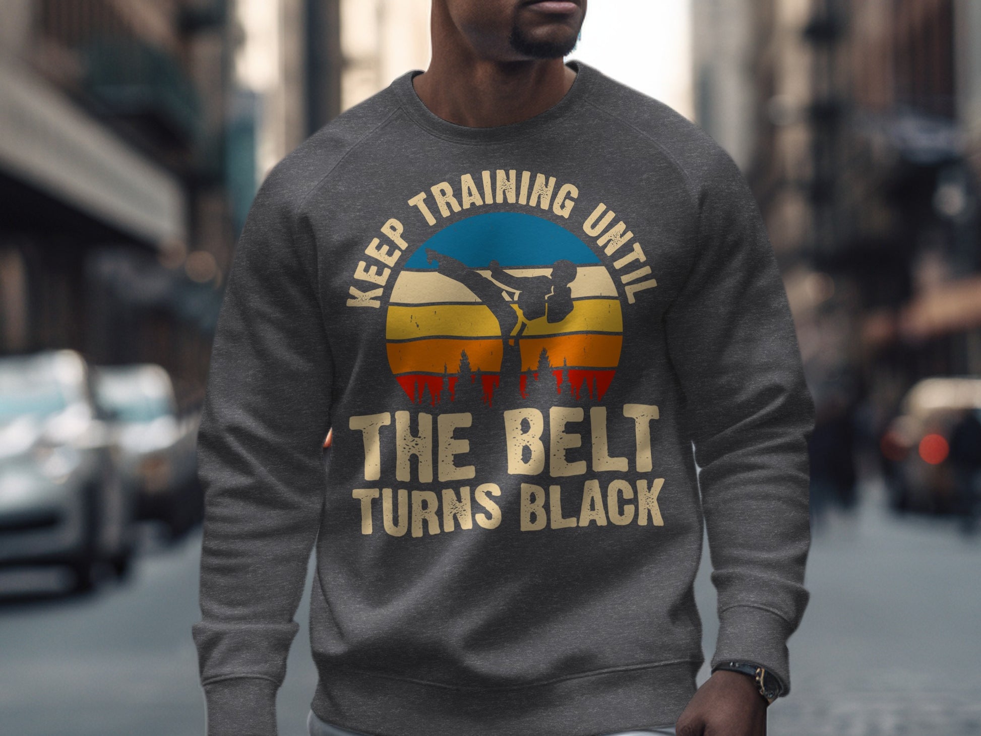 Grey sweatshirt with martial artist graphic and "Keep Training Until The Belt Turns Black" text.