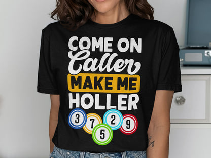 Black t-shirt with text "COME ON CALLER MAKE ME HOLLER" and colorful bingo balls.