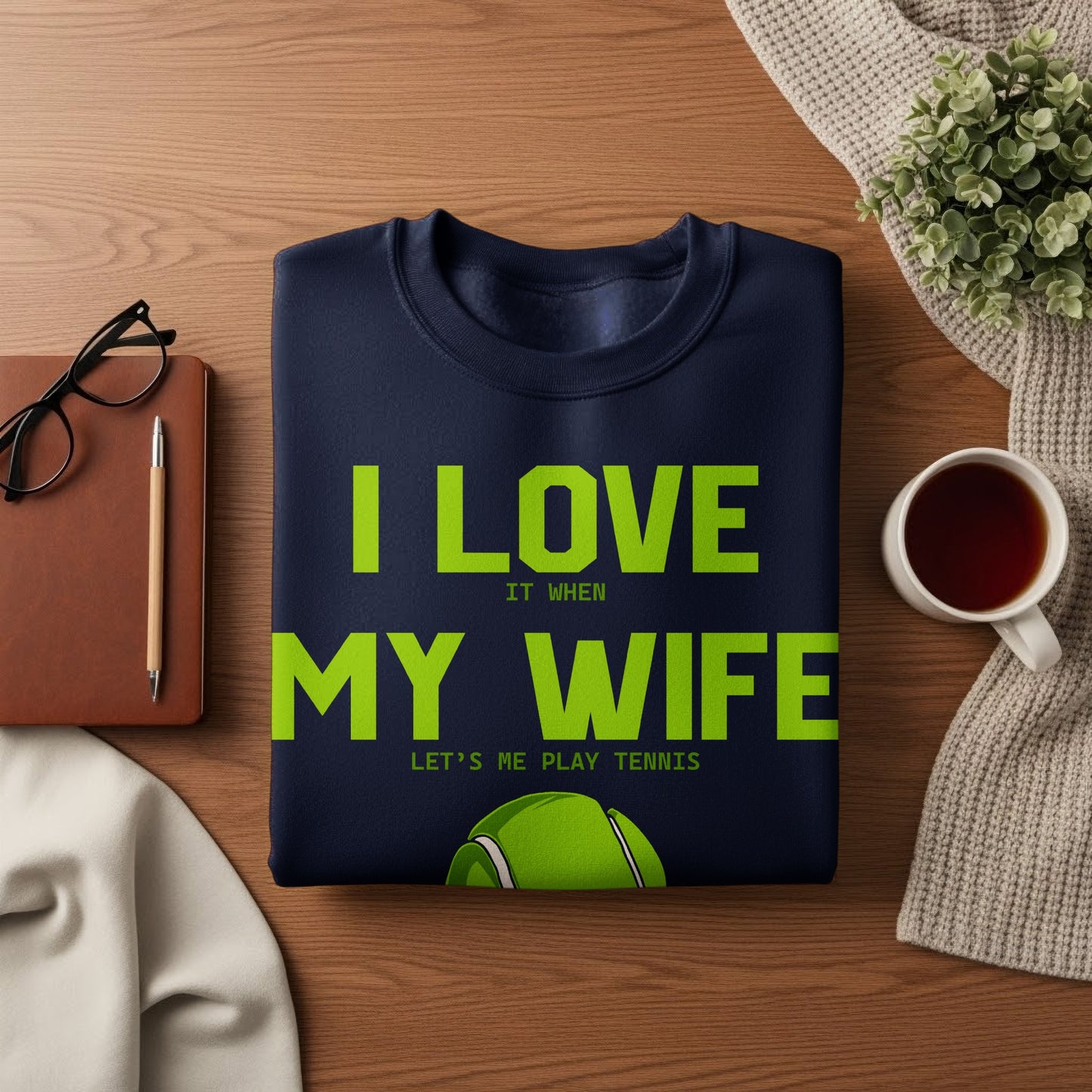 Navy sweatshirt with text "I LOVE MY WIFE LET'S ME PLAY TENNIS" and tennis ball.