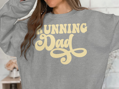 Grey sweatshirt with yellow "Running Dad" text in a retro font.
