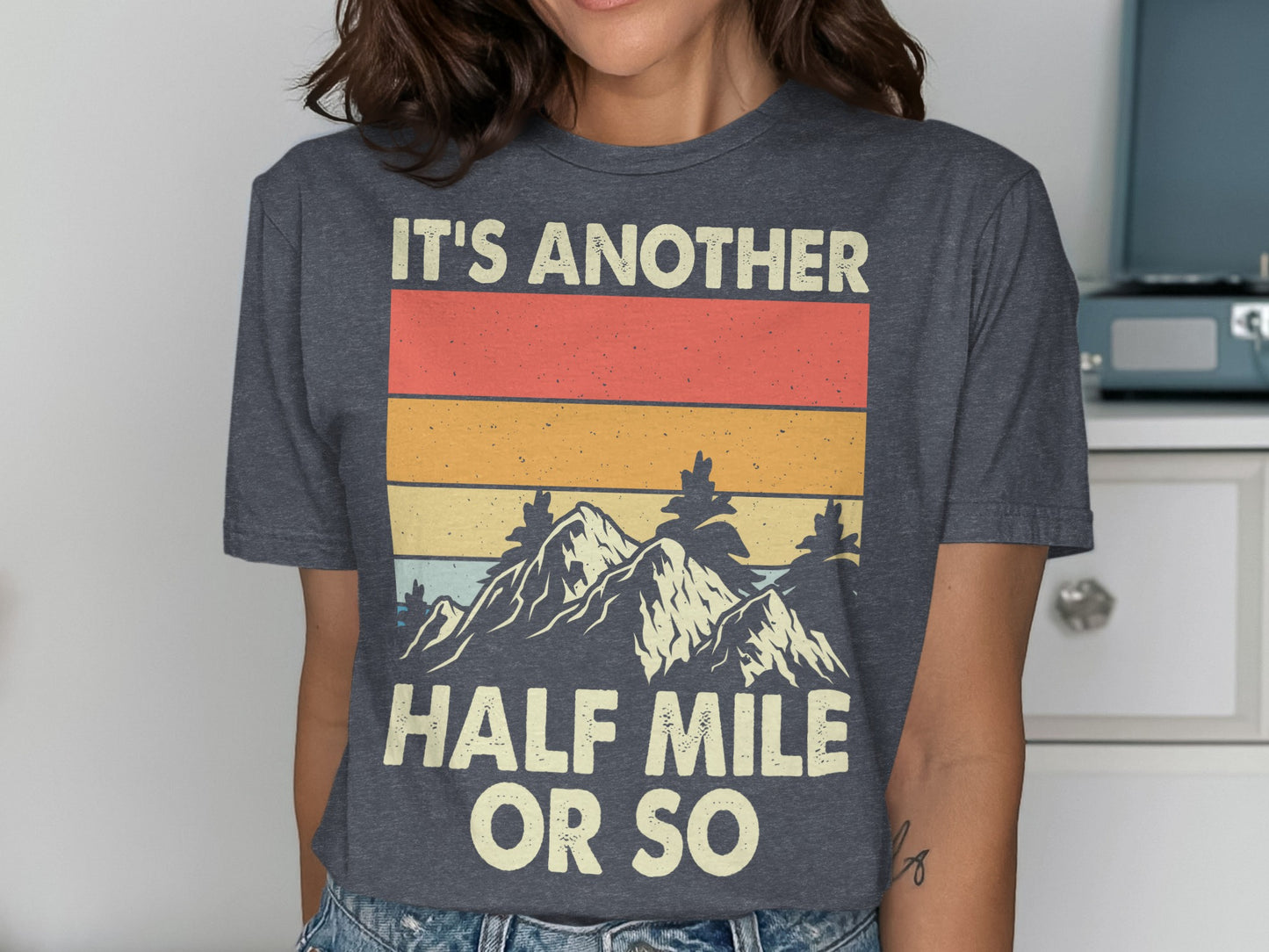 Dark grey t-shirt with "IT'S ANOTHER HALF MILE OR SO" and mountain design.