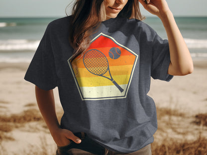 T-shirt with a geometric design featuring a tennis racket, ball, and sunset.