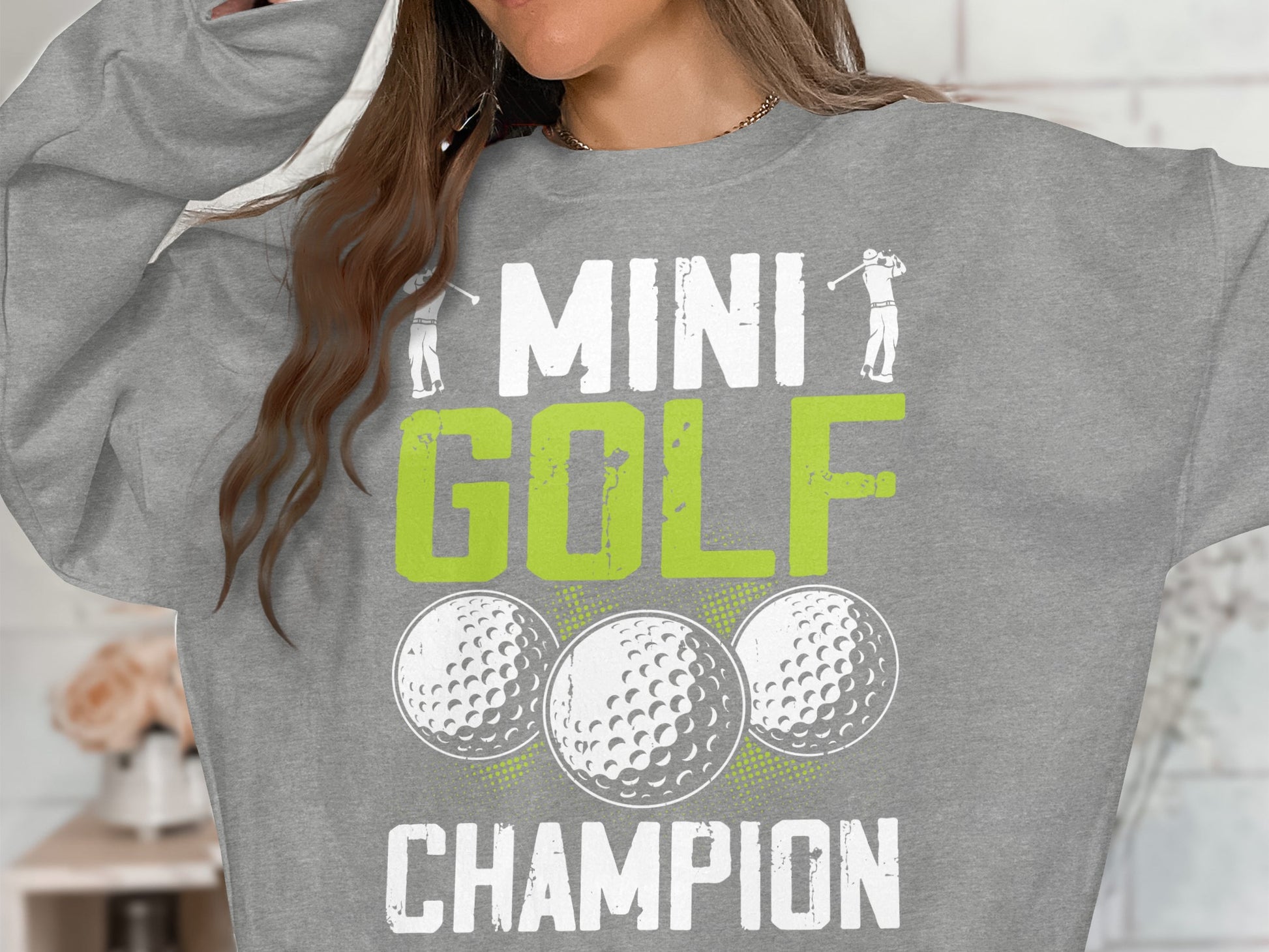 Gray sweatshirt with "MINI GOLF CHAMPION" and golf balls.