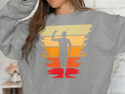Grey sweatshirt with a runner silhouette over a distressed sunset background.
