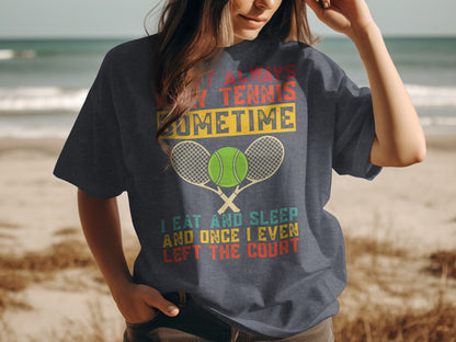 Dark t-shirt with tennis graphic and text: "I Eat Always Tennis Sometime I Eat and Sleep and Once I Even Left the Court"