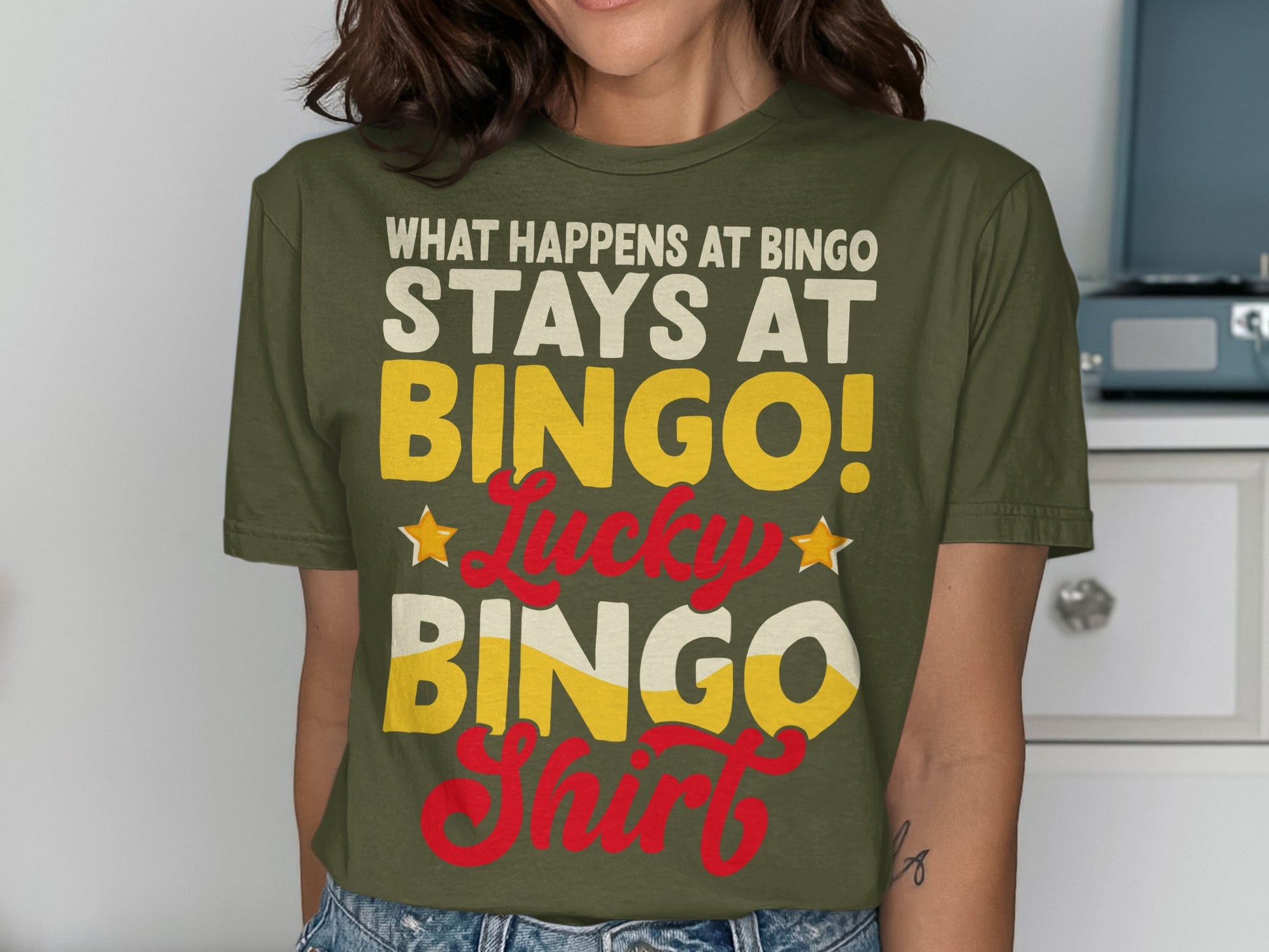 Green t-shirt with "What happens at bingo stays at bingo! Lucky Bingo Shirt" text.