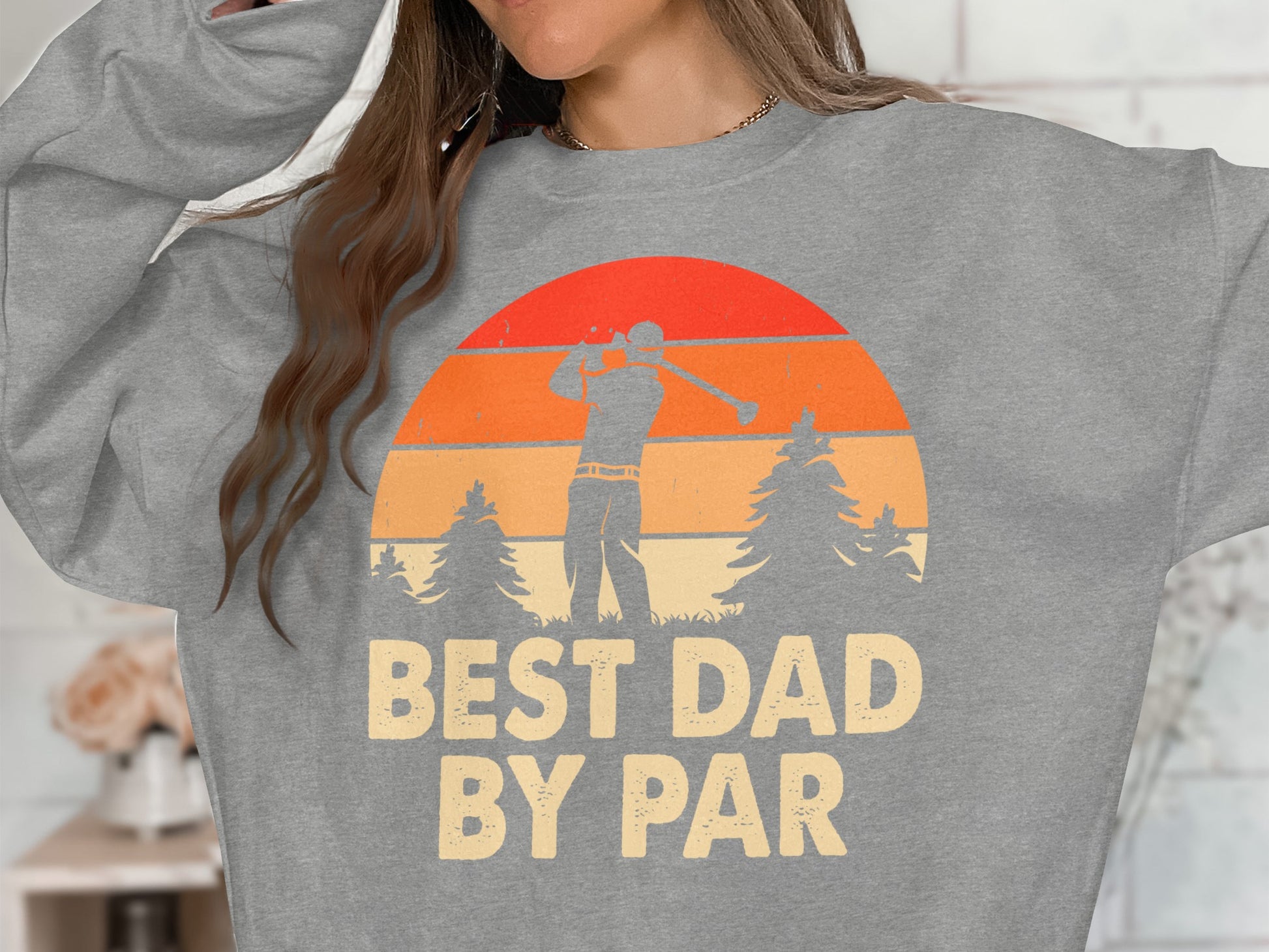 Gray sweatshirt with "BEST DAD BY PAR" text and golfer silhouette at sunset.