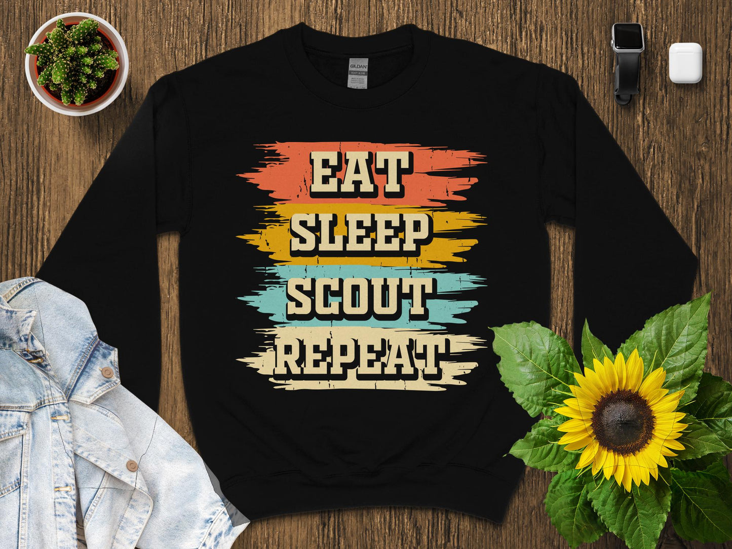 Black sweatshirt with "Eat Sleep Scout Repeat" in colorful distressed lettering.