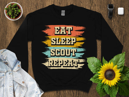 Black sweatshirt with "Eat Sleep Scout Repeat" in colorful distressed lettering.
