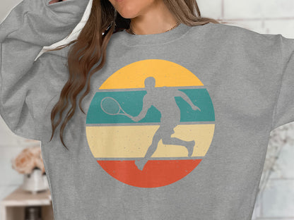 Grey sweatshirt with a circular graphic of a tennis player in retro colors.